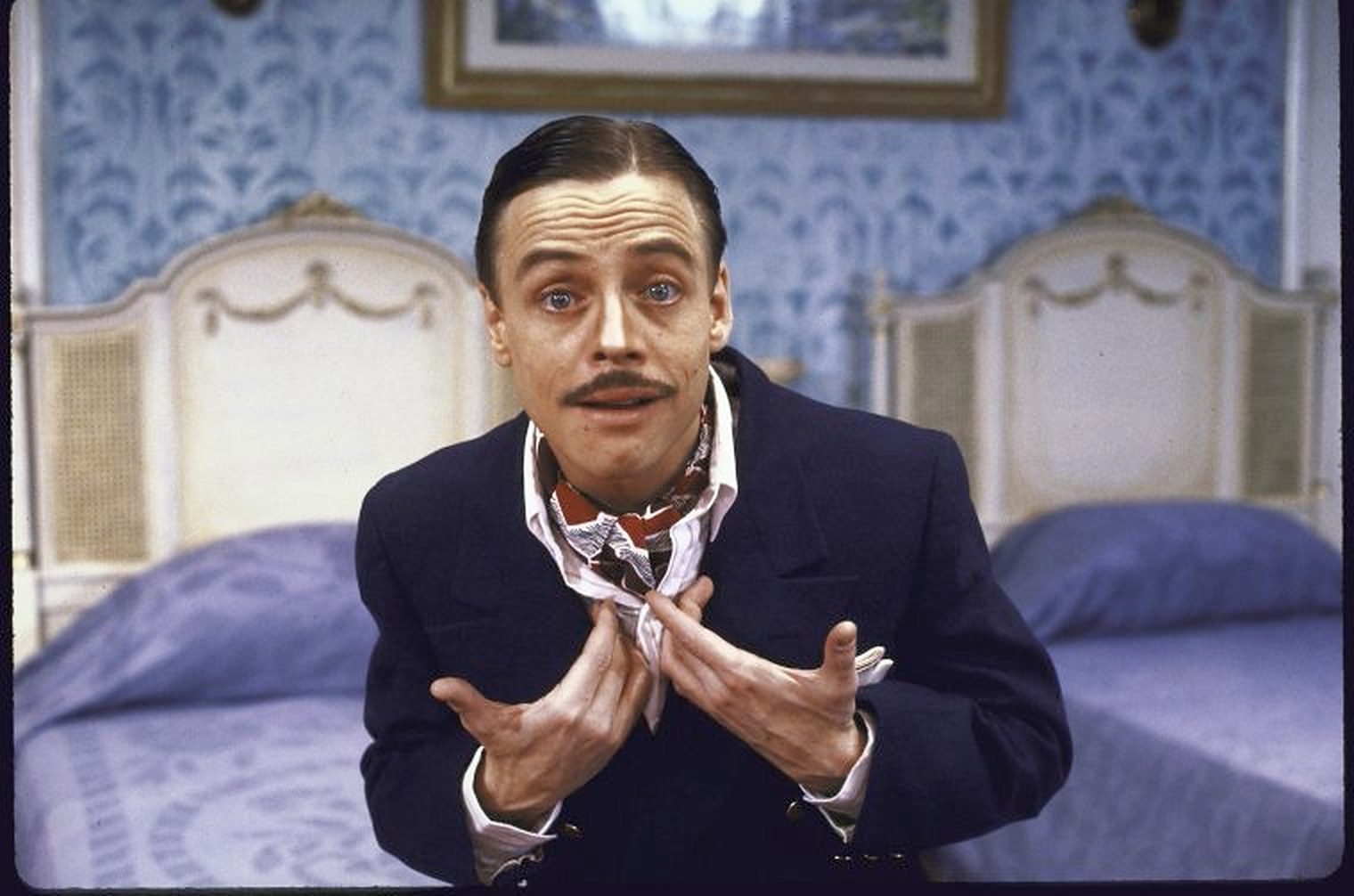 Mark Hamill in costume on a period set, gesturing